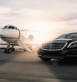 a car parked next to an airplane on a runway
