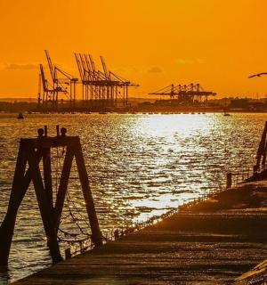 a sunset over a body of water with a dock