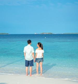 a man and a woman standing on the beach