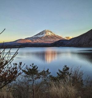 a mountain sitting on top of a body of water