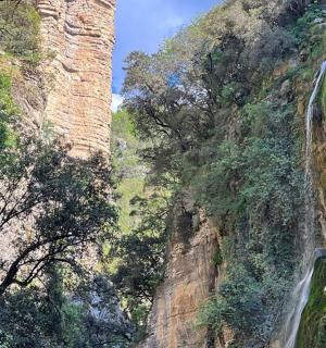 a canyon with a waterfall on the side of a mountain