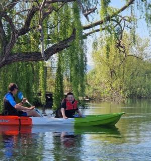 一名男子和一名儿童在河上的皮划艇上