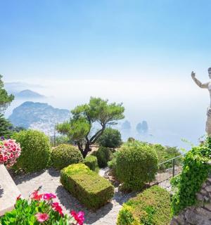 a statue of a woman in a garden with flowers