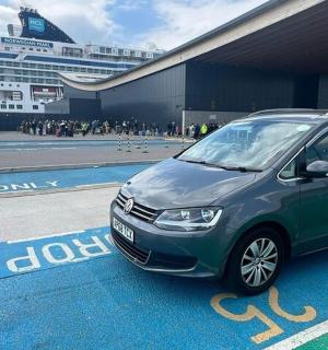 一辆绿色货车停在一艘游轮旁边