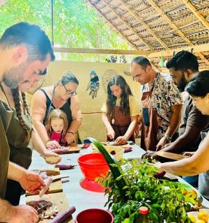 a group of people standing around a table preparing food