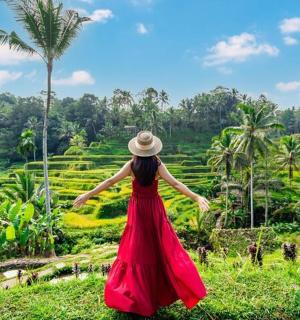 ผู้หญิงในชุดสีแดงกำลังมองไปที่ทุ่งนา