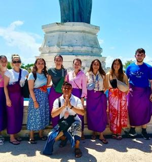 a group of people posing for a picture in front of a monument