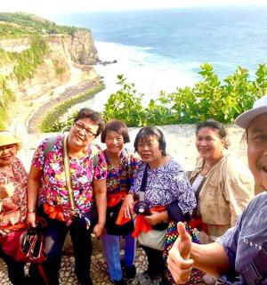 a group of people posing for a picture on a cliff