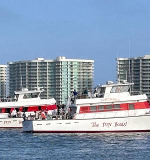 two boats in the water in front of tall buildings