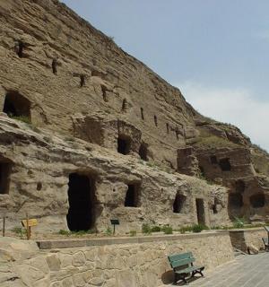 山边一座带长椅的石头建筑