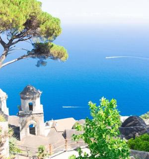 a church on a hill with the ocean in the background