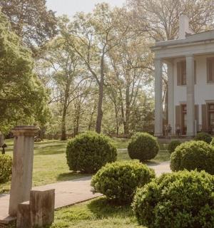 一栋白色大房子，门前有灌木丛