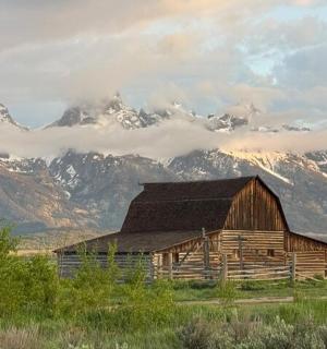 田野中的一座旧谷仓，背景是群山
