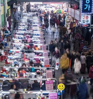una multitud de gent caminant per un mercat amb taules