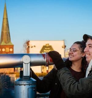 a man and two women looking through a telescope