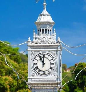a clock tower with street lights in front of it