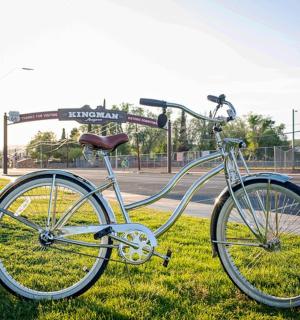 a bike parked in the grass next to a street