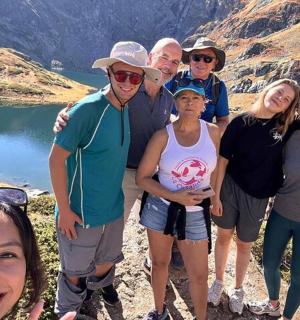 a group of people posing for a picture in front of a mountain