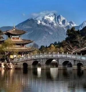 a bridge over a lake in front of a mountain