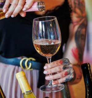 ผู้หญิงคนหนึ่งกำลังรินไวน์ใส่แก้ว