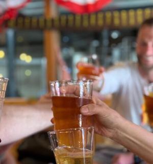 a group of people holding up glasses of beer