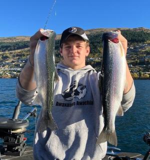 船上一名男子手里拿着两条鱼