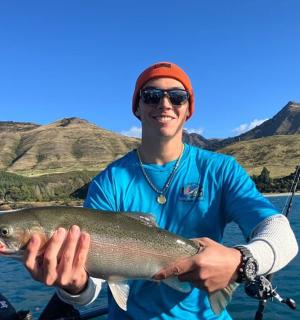 一名男子在水面上手里拿着一条鱼