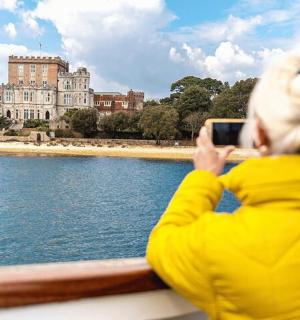 a woman taking a picture of a building on the water