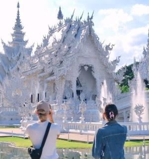 两个人站在一座白色寺庙前