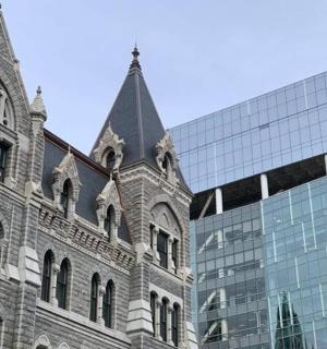 一座玻璃建筑旁边是一座钟楼建筑