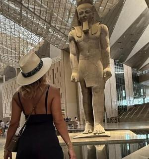 一名女子走过一栋建筑的雕像前