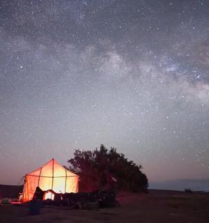 夜晚田野中央亮着灯的帐篷