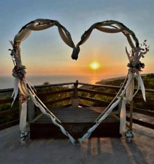 a heart shaped swing with the sunset in the background