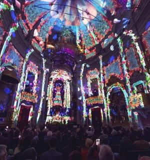 a large group of people in a church with christmas lights