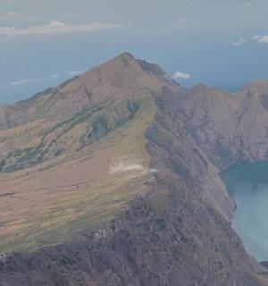 an aerial view of a mountain with a body of water