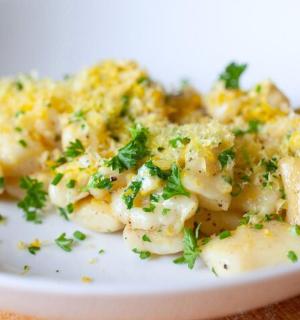 a white plate of potatoes with parsley on it