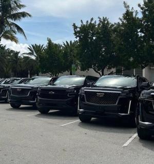 a row of black trucks parked in a parking lot