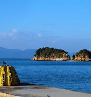 a large yellow object sitting on the side of a body of water