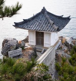 malá budova na skalách u vody