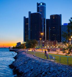 eine Skyline einer Stadt bei Nacht mit einem Fluss und Gebäuden