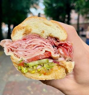 ruka držící sendvič s masem a zeleninou