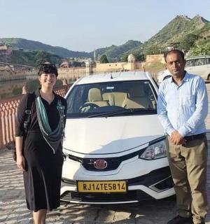 a man and a woman standing next to a white car