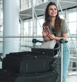 a woman is looking at her cell phone next to luggage