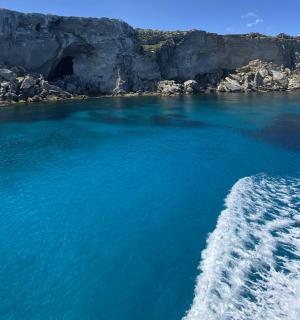 a boat in the water next to a cliff