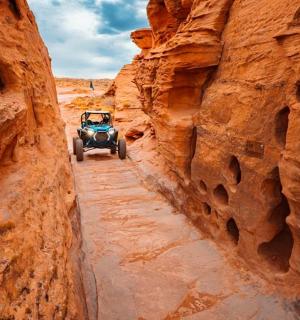 一辆吉普车沿着峡谷中的土路行驶