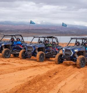 一群人骑着四轮摩托车在土路上行驶