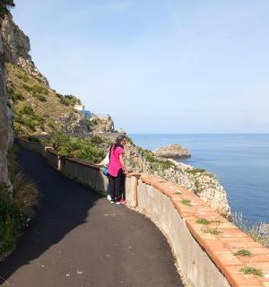 žena stojící na zdi poblíž oceánu