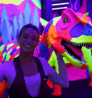 一位女士站在恐龙服装前