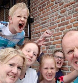 skupina lidí stojící vedle cihlové zdi