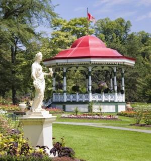 a statue in a garden with a gazebo
